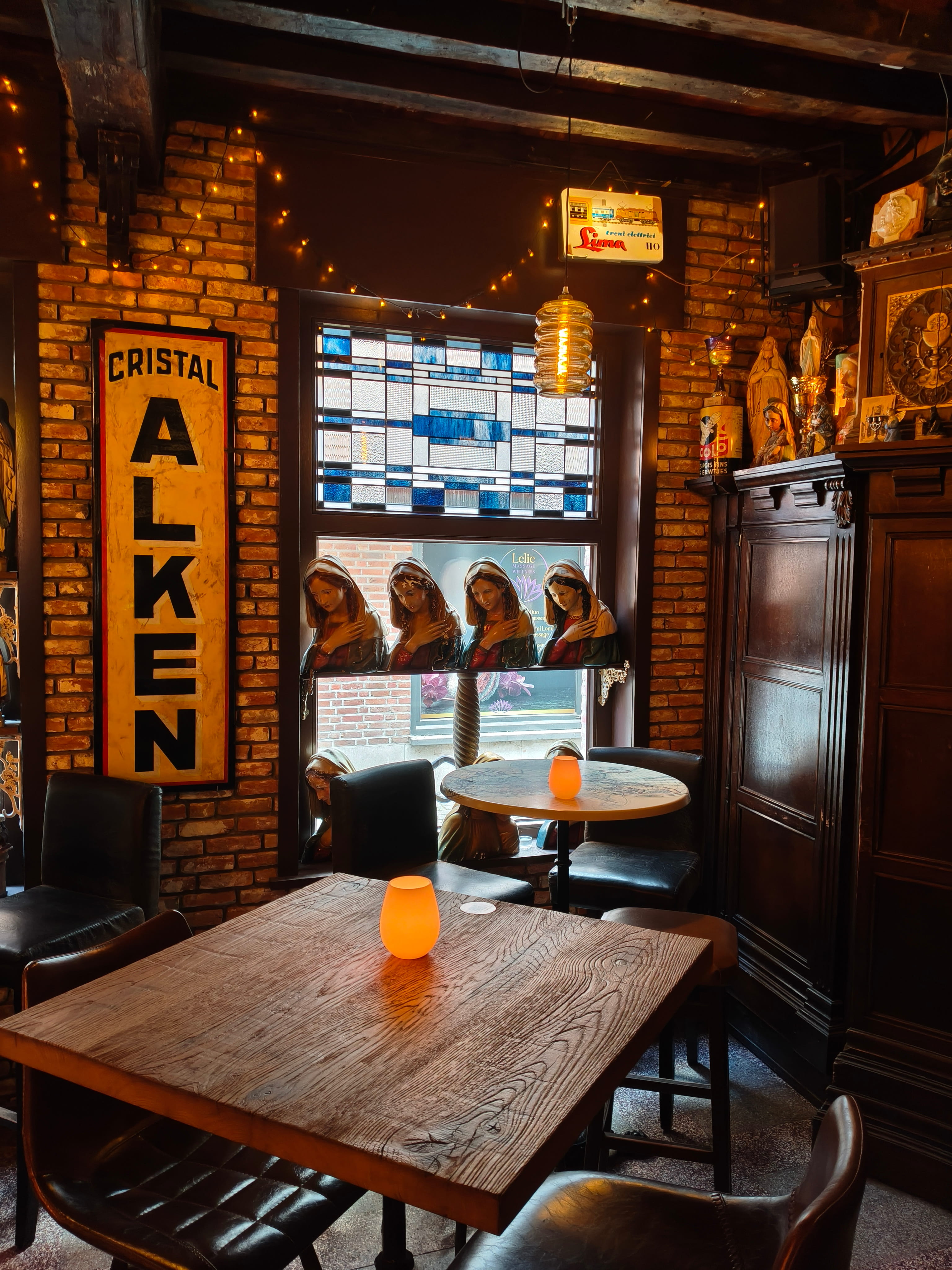 Sfeervolle detailopname van warm kaarslicht op een houten cafétafel